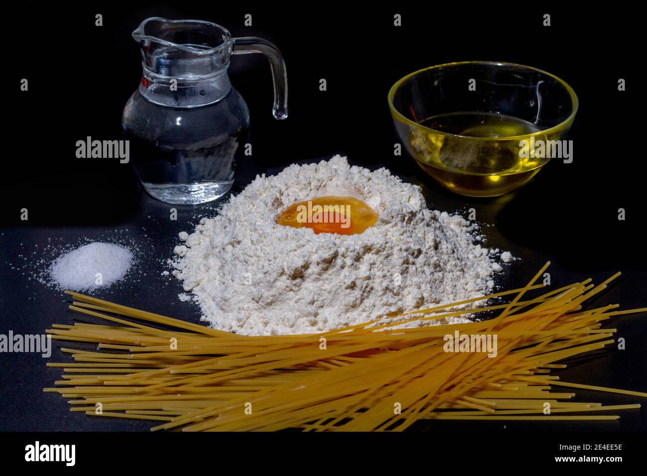 Alle Zutaten, um Spaghetti zu bekommen. Mehl, Ei, Wasser, Olivenöl und Salz, notwendig, um Spaghetti zu machen. Stockfoto