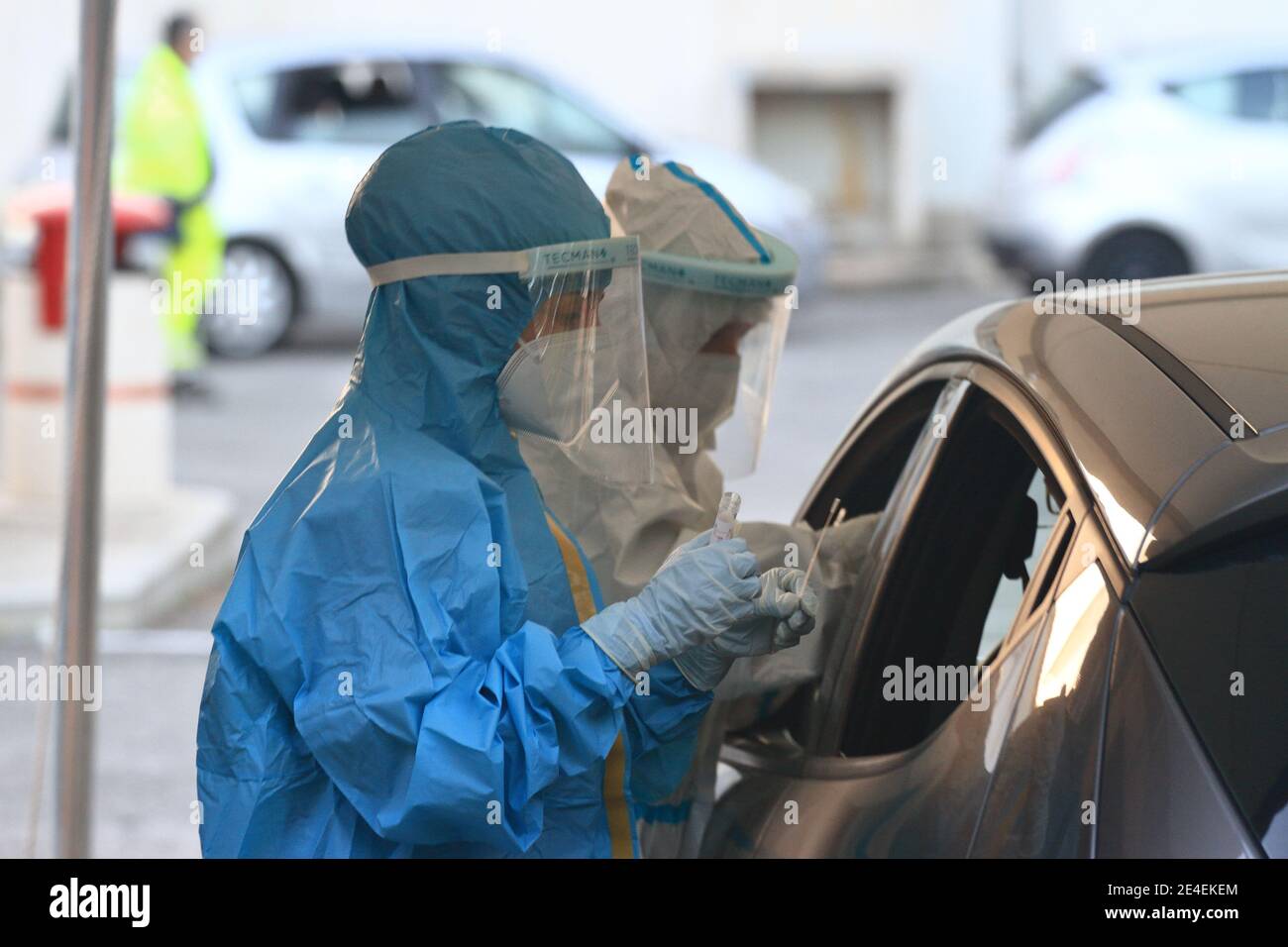 Arzt mit Maske und Visier macht Tampon zu Person im Auto für den Notfall covid-19 sitzen. Stockfoto