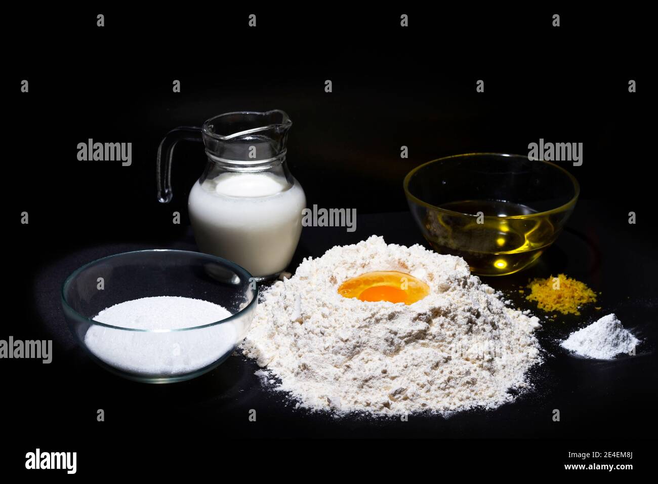 Zutaten für Biskuitkuchen. Mehl, Ei, Zucker, Milch, Olivenöl und Hefe sind die notwendigen Zutaten, um Biskuitkuchen, Kuchenbasen oder Torten zu machen. Stockfoto