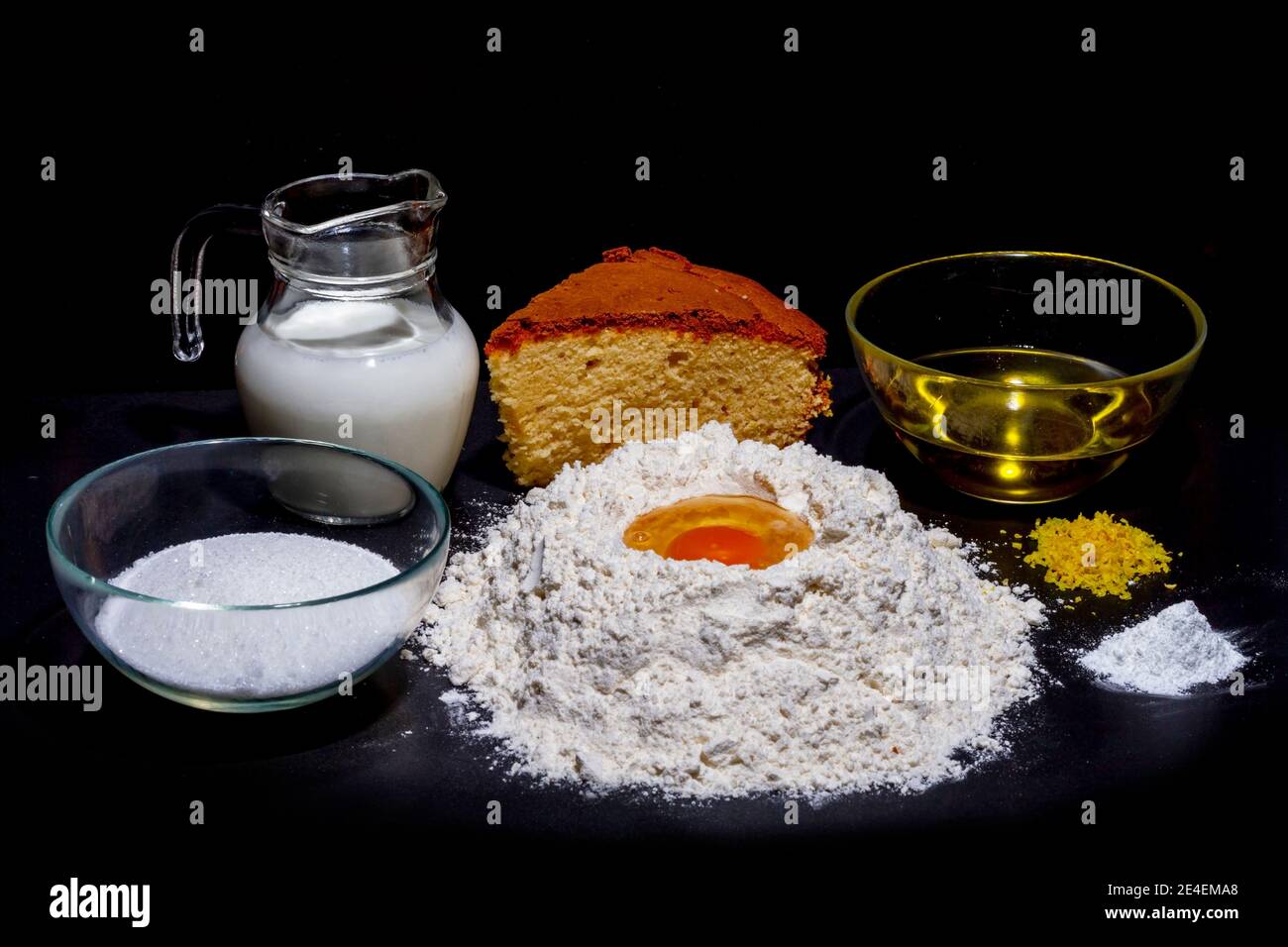 Zutaten für Biskuitkuchen. Mehl, Ei, Zucker, Milch, Olivenöl und Hefe sind die notwendigen Zutaten, um Biskuitkuchen, Kuchenbasen oder Torten zu machen. Stockfoto