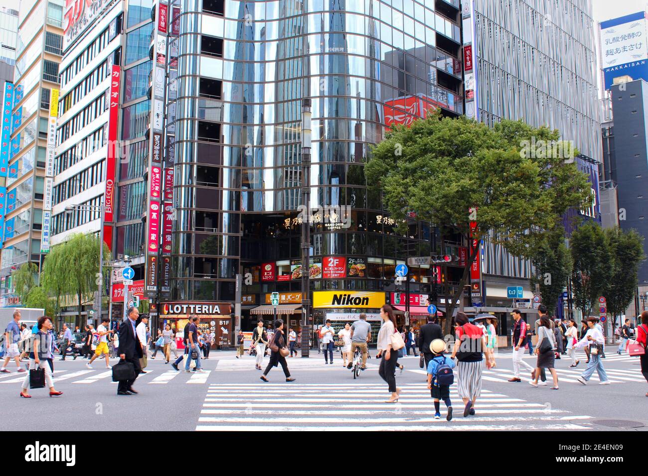 Fußgänger überqueren Kreuzung in Ginza. Ginza ist Japans berühmtes Luxus-Einkaufs- und Unterhaltungsviertel. Menschen, die aus allen Richtungen kommen. Stockfoto