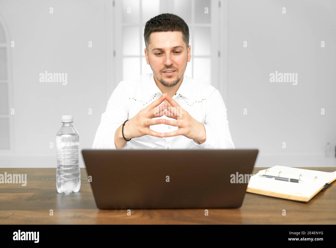 Manager, der an einem Projekt im Freiraumbüro arbeitet. Papierkram, Flasche mit Wasser und Laptop auf dem Tisch Stockfoto