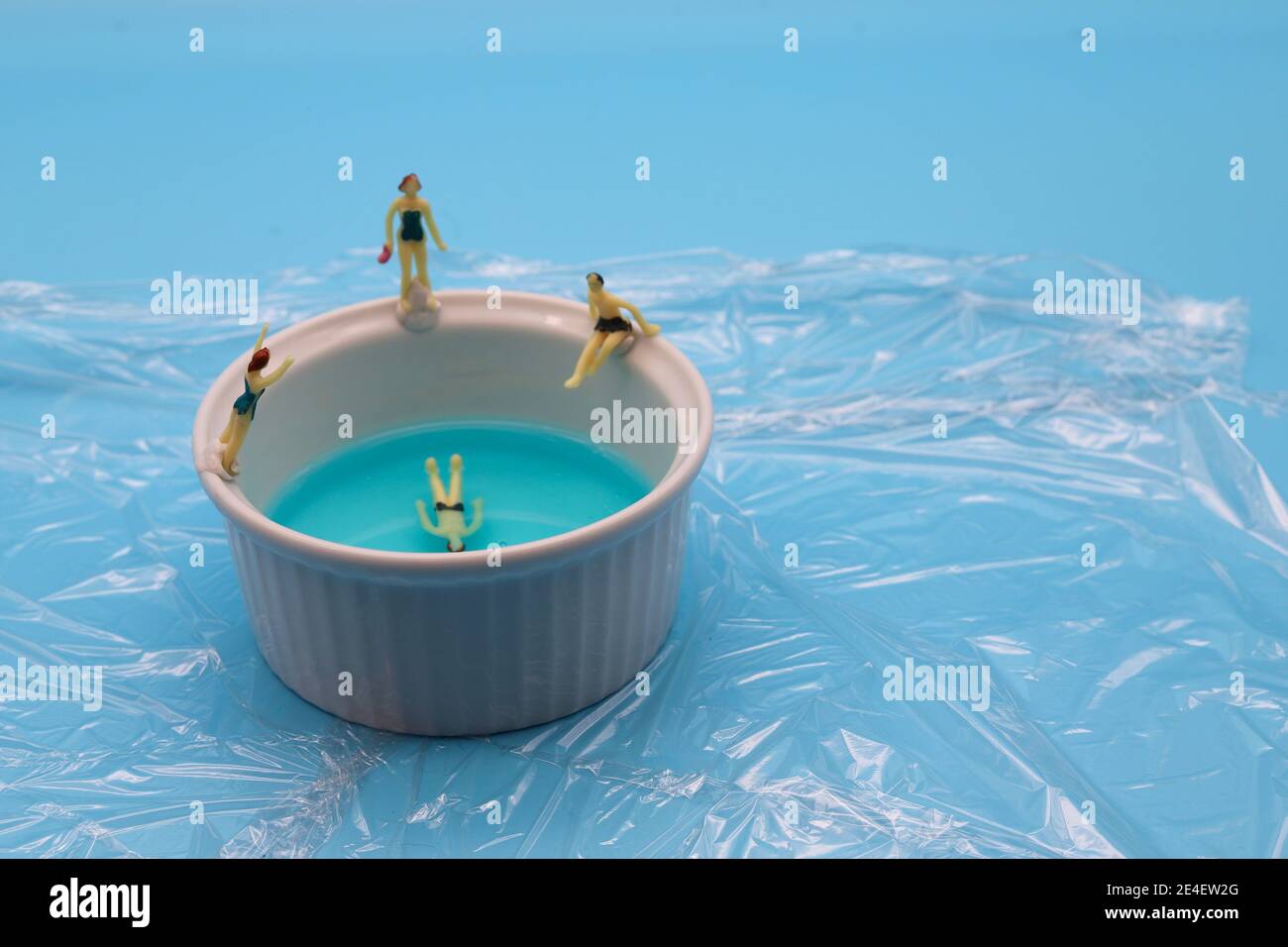 Miniatur-Schwimmer und ein Anti-Bac-Ramekin-Pool. Stockfoto