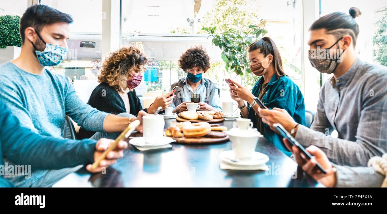 Menschen mit mobilen Smartphones an der Kaffeebar - Neu Normales Sammelkonzept über gelangweilte Freunde, die Inhalte online teilen Soziale Netzwerke Stockfoto