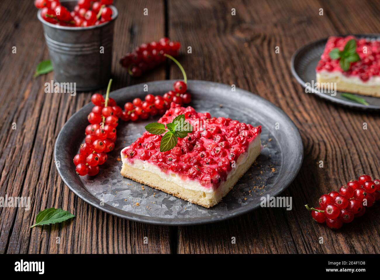 Süßes Dessert mit roten Johannisbeeren gefüllt mit Frischkäse, dekoriert mit frischen Beeren auf Holzhintergrund Stockfoto