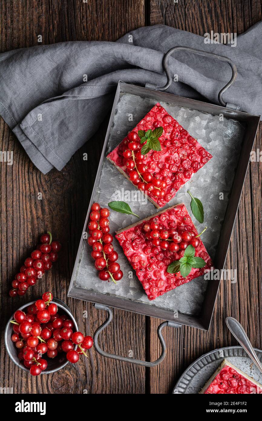 Süßes Dessert mit roten Johannisbeeren gefüllt mit Frischkäse, dekoriert mit frischen Beeren auf Holzhintergrund Stockfoto