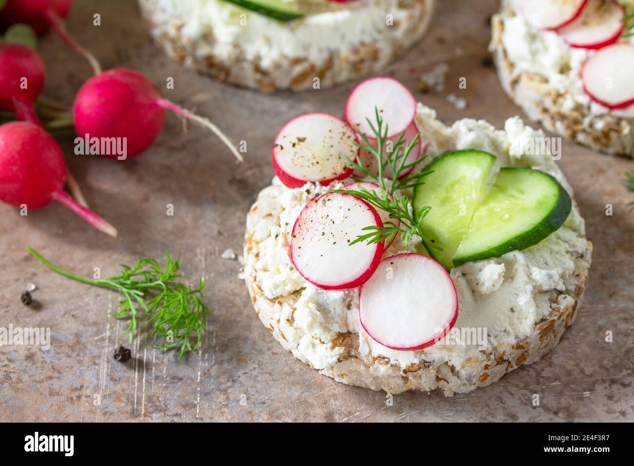 Sandwiches Knäckebrot mit Ricotta, Rettich und frischer Gurke auf einer ...