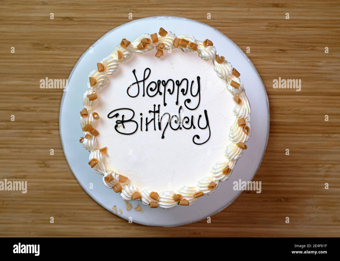 Weiße Gourmet-Geburtstagstorte mit einem "Happy Birthday"-Schild, mit Buttercreme matt und mit Karamellspäne verziert Stockfoto