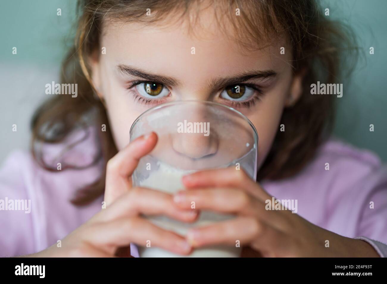 Mädchen trinkt Milch in einem Glas, in der Nähe der horizontalen Ebene.Selektive Fokus. Stockfoto