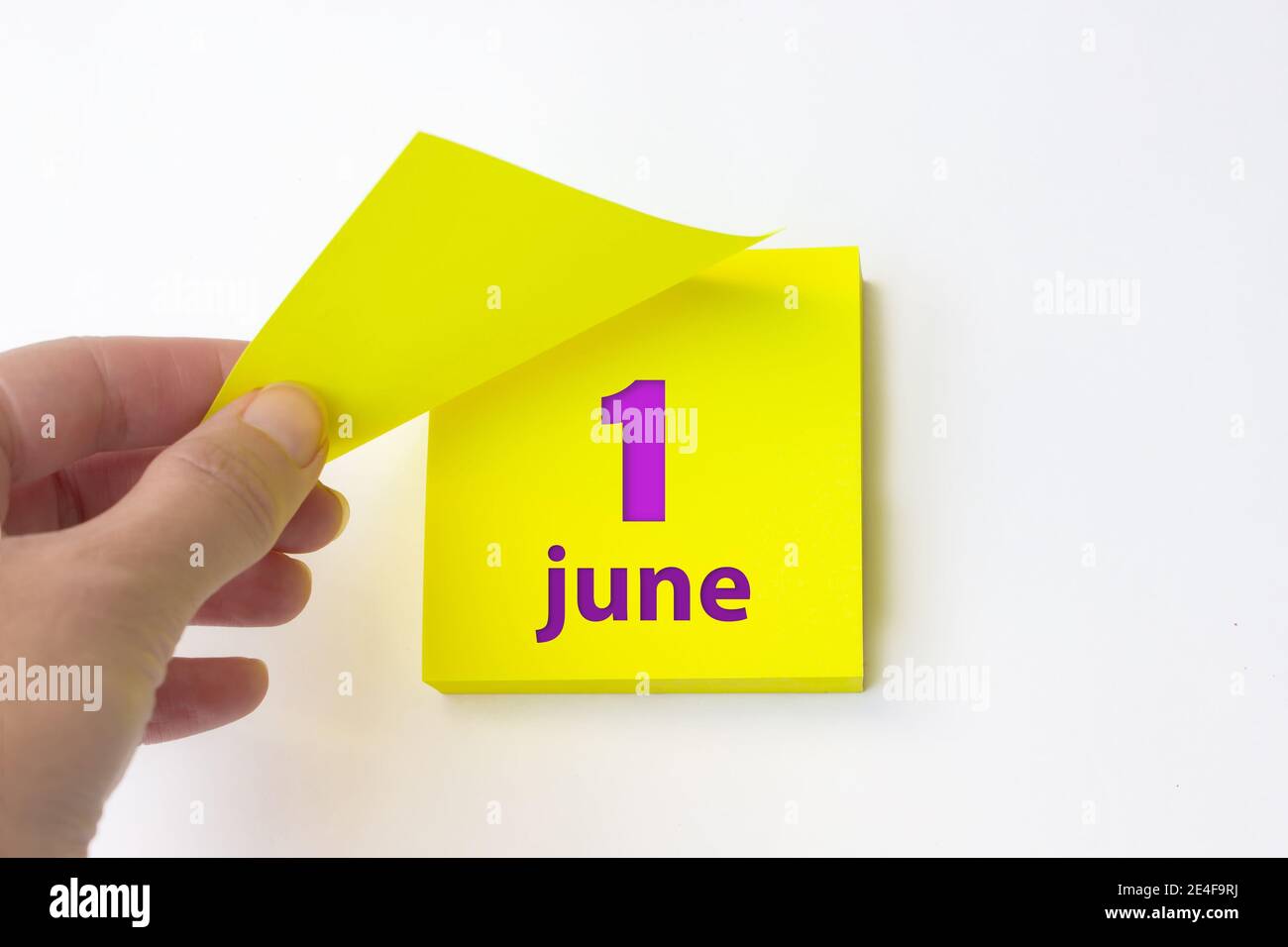 Juni . Tag 1 des Monats, Kalenderdatum. Die Hand reißt das gelbe Blatt des Kalenders ab. Sommer Monat, Tag des Jahres Konzept Stockfoto