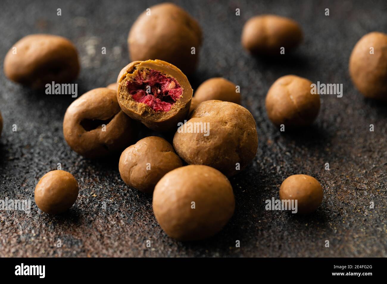 Süße goldfarbene Trüffel mit Cinamon, Kardamom und Nelke auf einem dunklen rustikalen Hintergrund Stockfoto