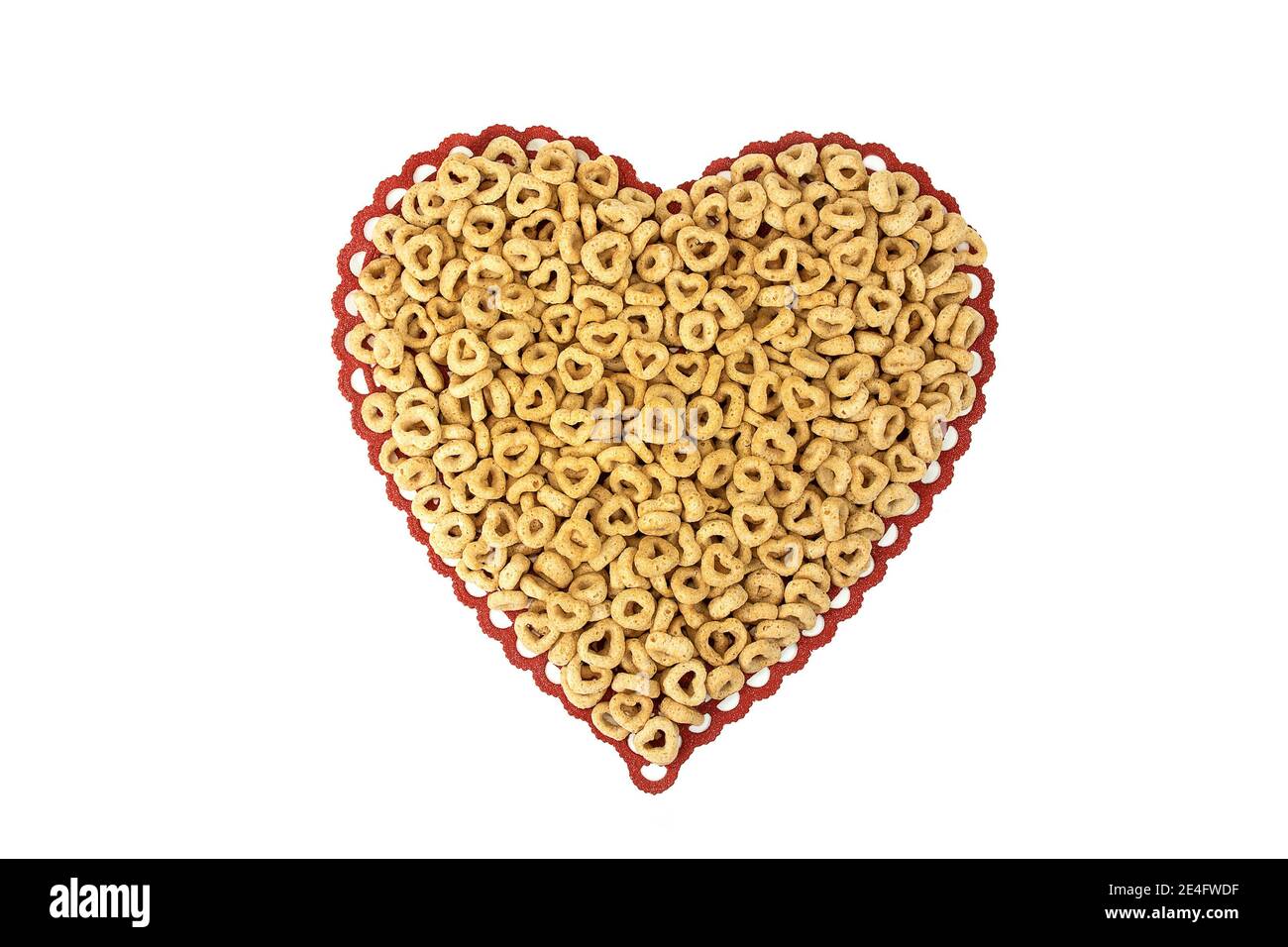 Nahaufnahme von Frühstückscerealien mit Kreisen und Herzen Rote Spitze Herz Deckchen auf weiß isoliert Stockfoto