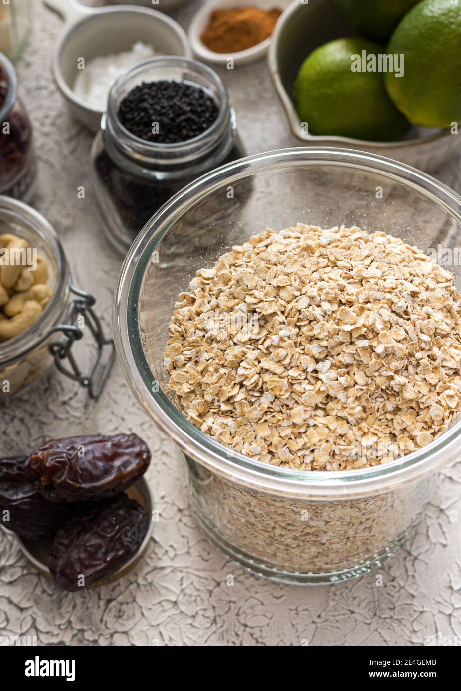 Granola-Rohzutaten in Schalen und Gläsern. Stockfoto