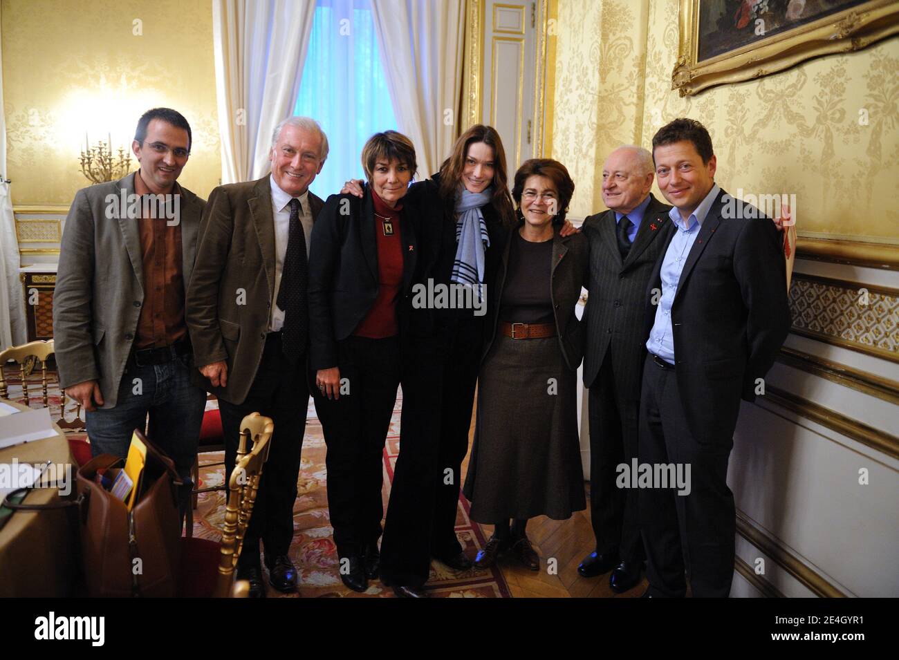 Französisch First Lady Carla Bruni-Sarkozy (C) posiert für ein Bild mit dem Präsidenten der Helfer, eine Vereinigung, um Menschen mit HIV infiziert helfen, Bruno Spire (R), Französisch Präsident der Sidaction, Pierre Berge (2ndR), Freunde des Mundial Fonds Präsident Michele Barzach (3rdR), präsident der internationalen Vereinigung für HIV-infizierte, Solthis, Christine Katlama (3rdl), Präsident der Nationalen Agentur für Forschung gegen AIDS (Agence Nationale de Recherche contre le Sida) Jean-Francois Delfraissy (2ndl) und Präsidentin des Familienverbandes Reda Sadki (L) nach einem Treffen im Rahmen des Welt-Aids-Tages, AT Stockfoto