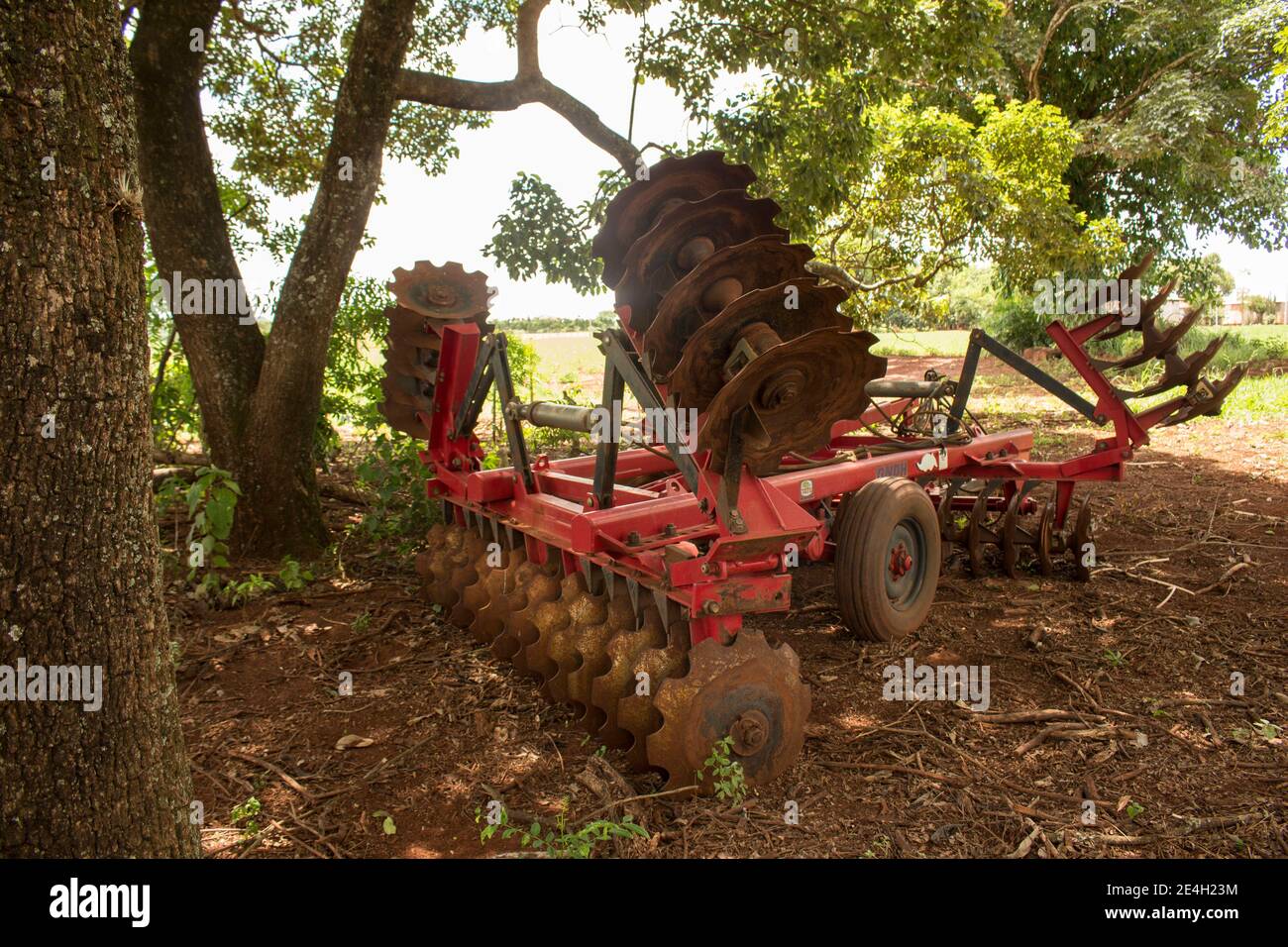 Ibitinga / Sao Paulo / Brasilien - 01 23 2020: Isolierte rote Landmaschinen für die Vorbereitung des Feldes (Boden) stehen allein unter dem Schatten Stockfoto