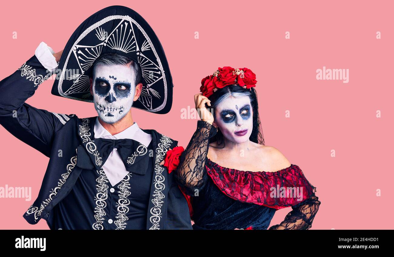 Junges Paar Tragt Mexikanische Tag Der Toten Kostum Uber Hintergrund Verwirren Und Fragen Sich Uber Frage Unsicher Mit Zweifel Denken Mit Hand Auf Stockfotografie Alamy