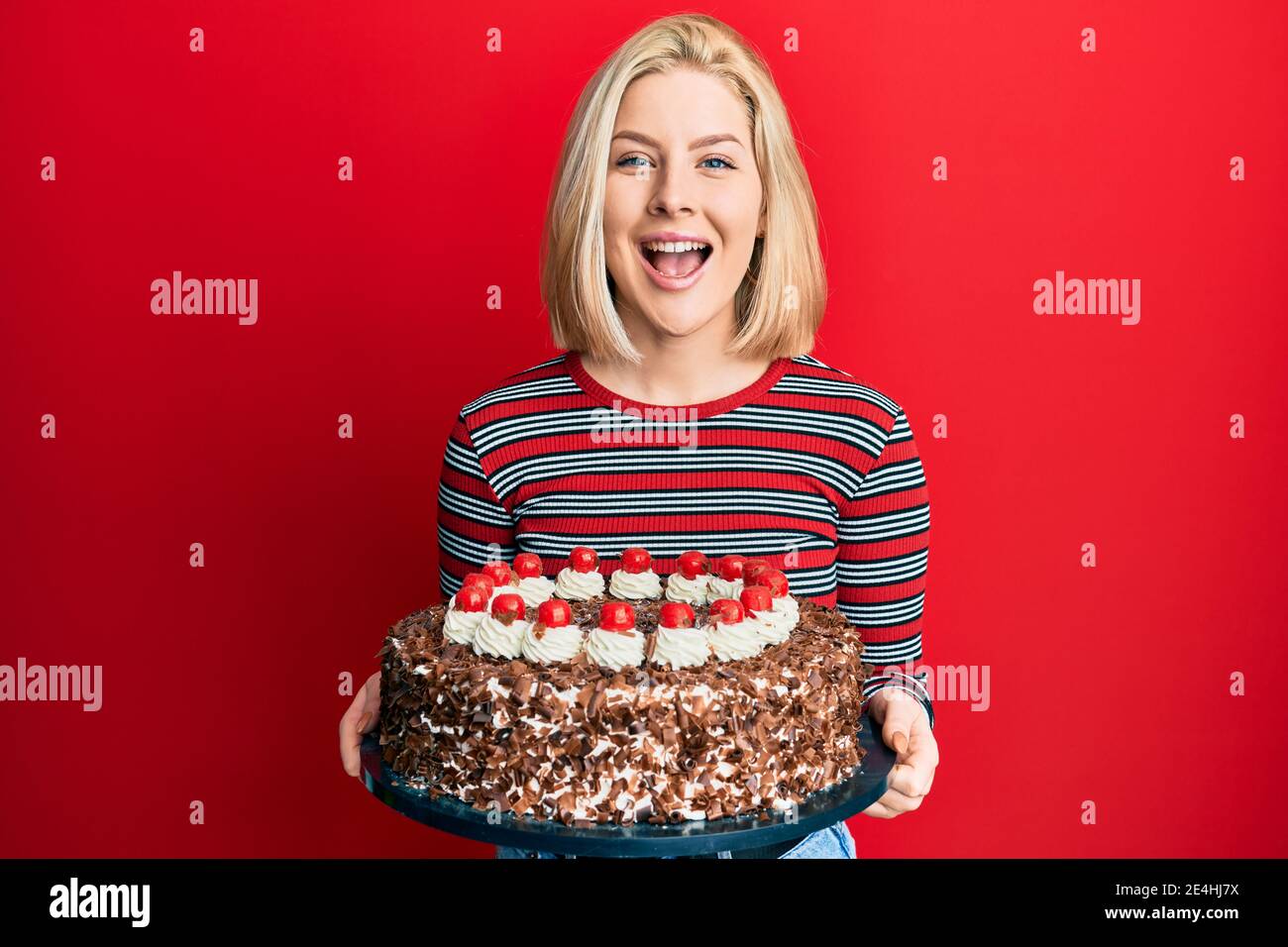 Junge blonde Frau feiert Geburtstag mit großen Schokoladenkuchen ...