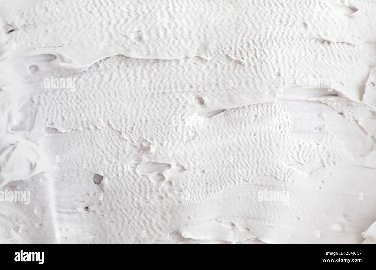 Raue, dichte Striche von dicker Farbe. Weiße abstrakte Textur der Oberfläche mit Volumen Relief Struktur von Kitt Stockfoto
