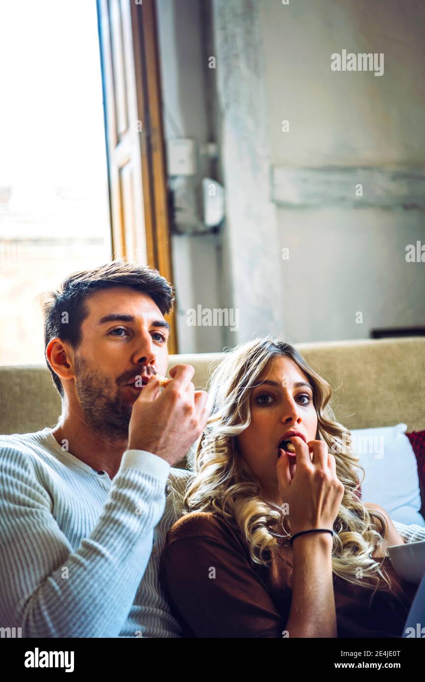 Junges Paar zu Hause essen Popcorn und Film Stockfoto