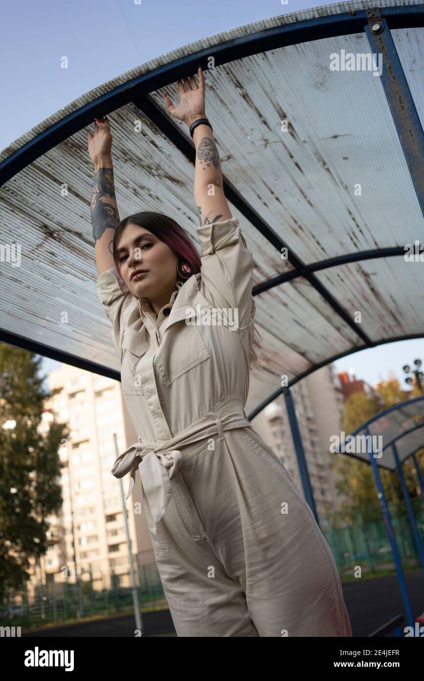 Modische junge Frau mit coolen Haltung greifen auf Dach in Sportplatz Stockfoto