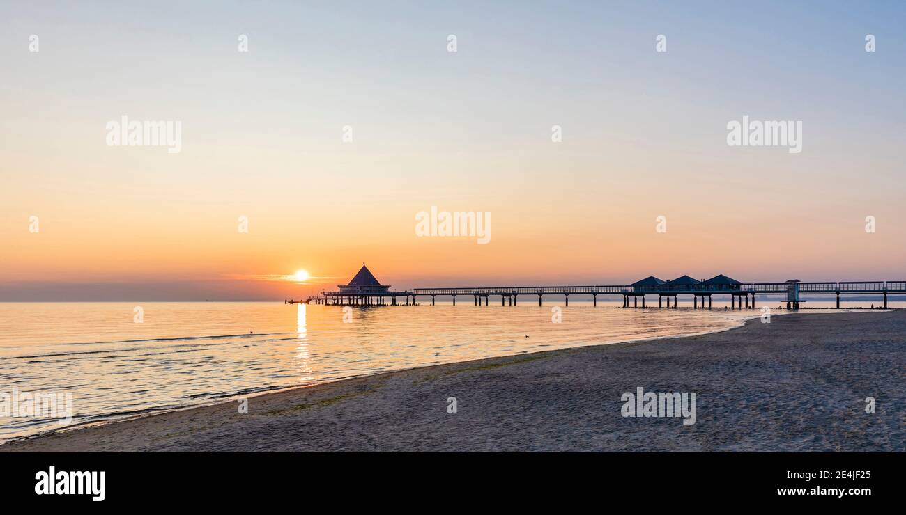 Deutschland, Mecklenburg-Vorpommern, Heringsdorf, Sandstrand bei Sonnenaufgang mit Heringsdorf Pier im Hintergrund Stockfoto