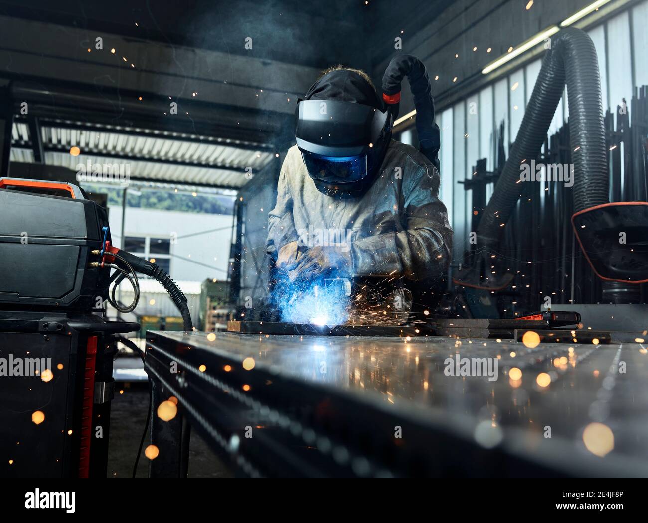 Metallarbeiter tragen Arbeitsschutzkleidung Schweißen Metall während der Arbeit an Werk Stockfoto