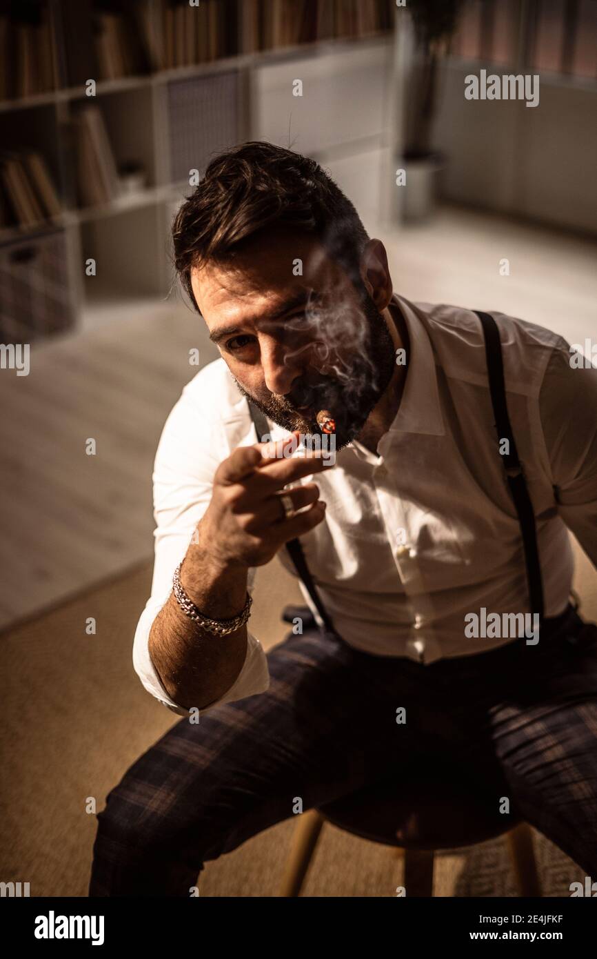 Porträt eines bärtigen Mannes, der Zigarre raucht Stockfoto