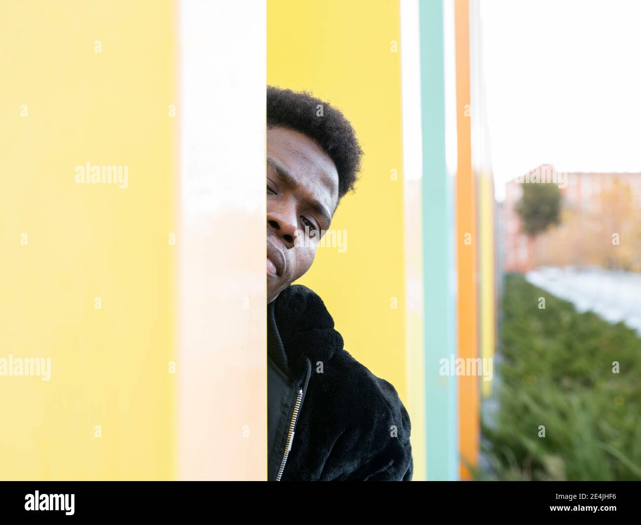 Junger Mann hinter der Wand Stockfoto