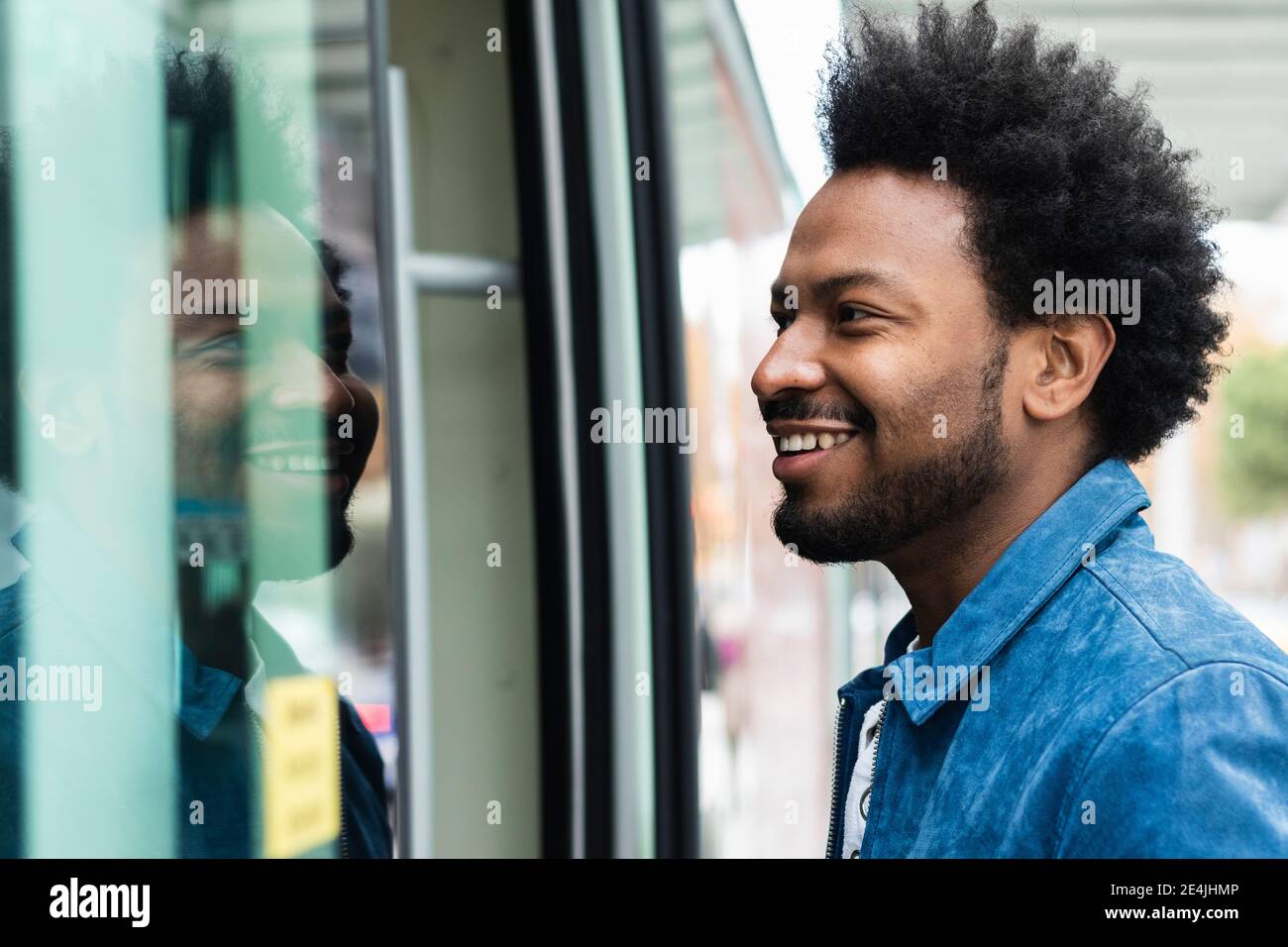 Nahaufnahme eines stylischen Mannes mit mittlerem Erwachsenenalter und eintretenden Afro-Haaren In den Bus Stockfoto