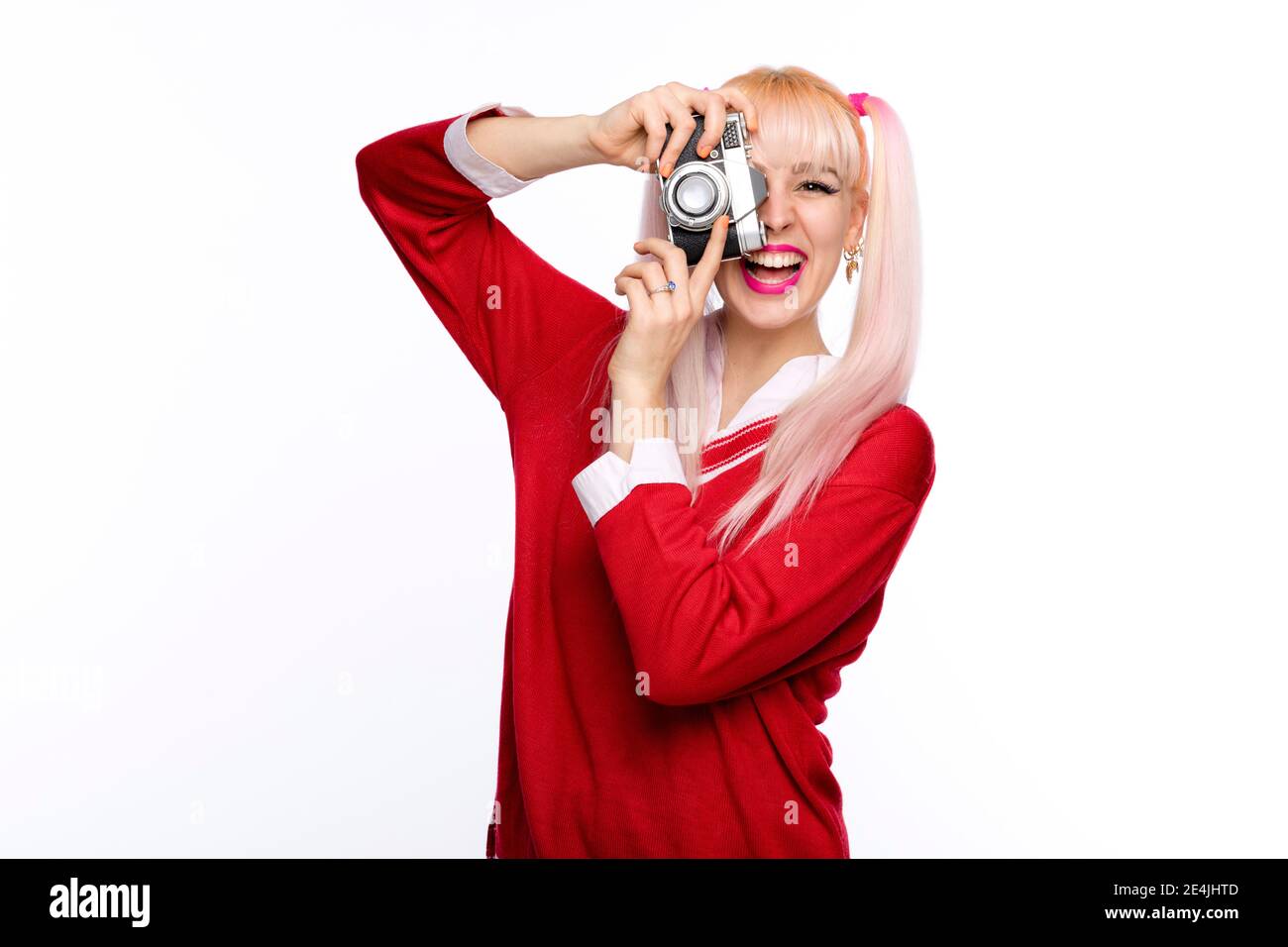 Fröhliche junge Frau fotografiert durch Vintage-Kamera Stockfoto Fröhliche junge Frau fotografiert durch Vintage-Kamera Stockfoto