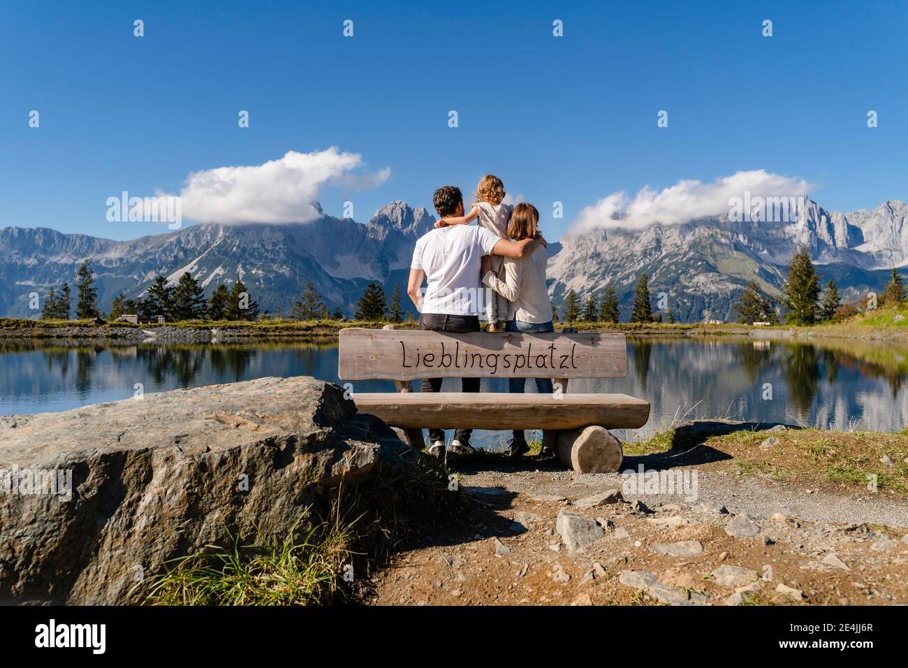Familie mit einer kleinen Tochter, die zusammen hinter der Seeuferbank steht Im Kaisergebirge Stockfoto