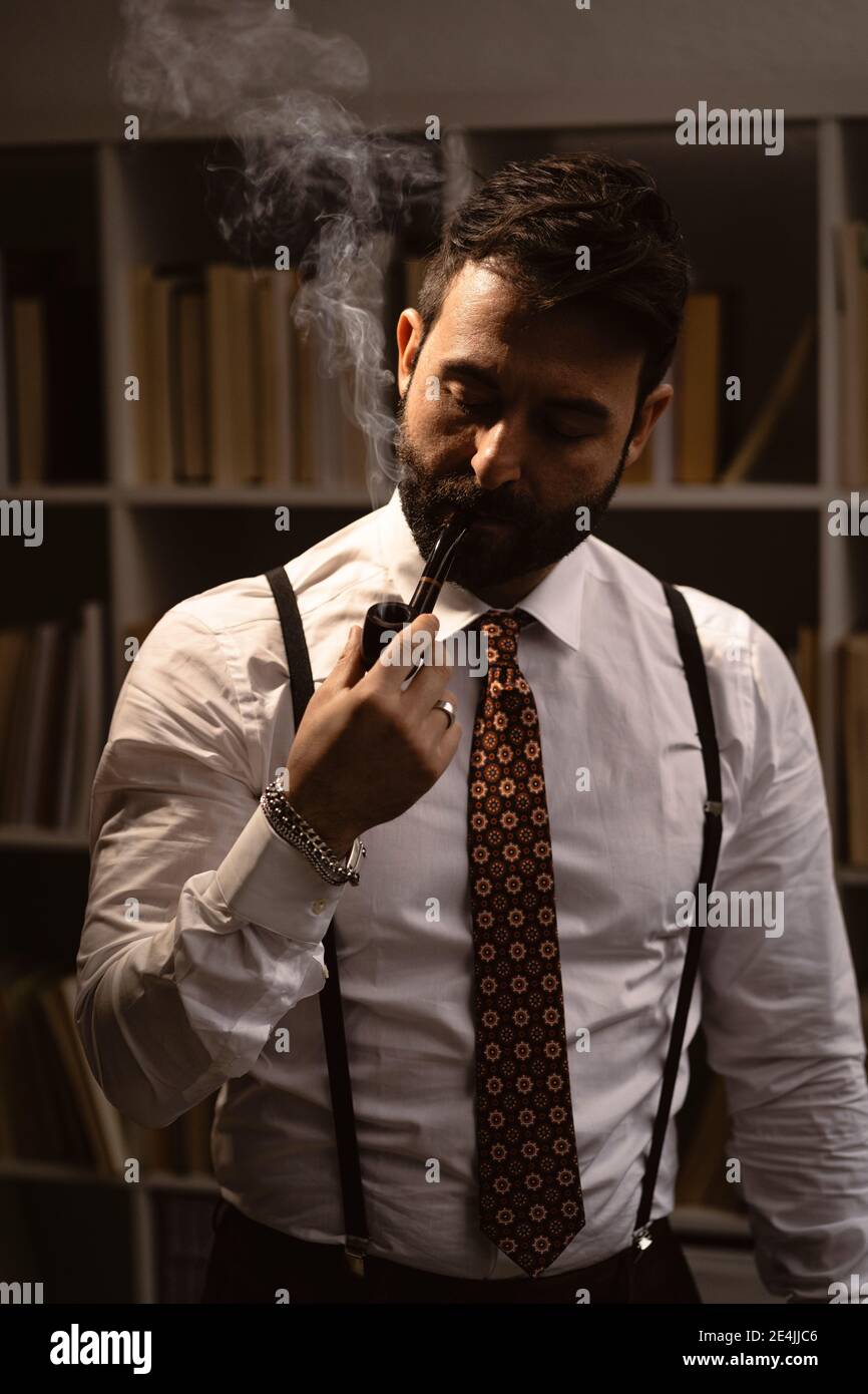 Porträt eines bärtigen Mannes, der Pfeife raucht Stockfoto