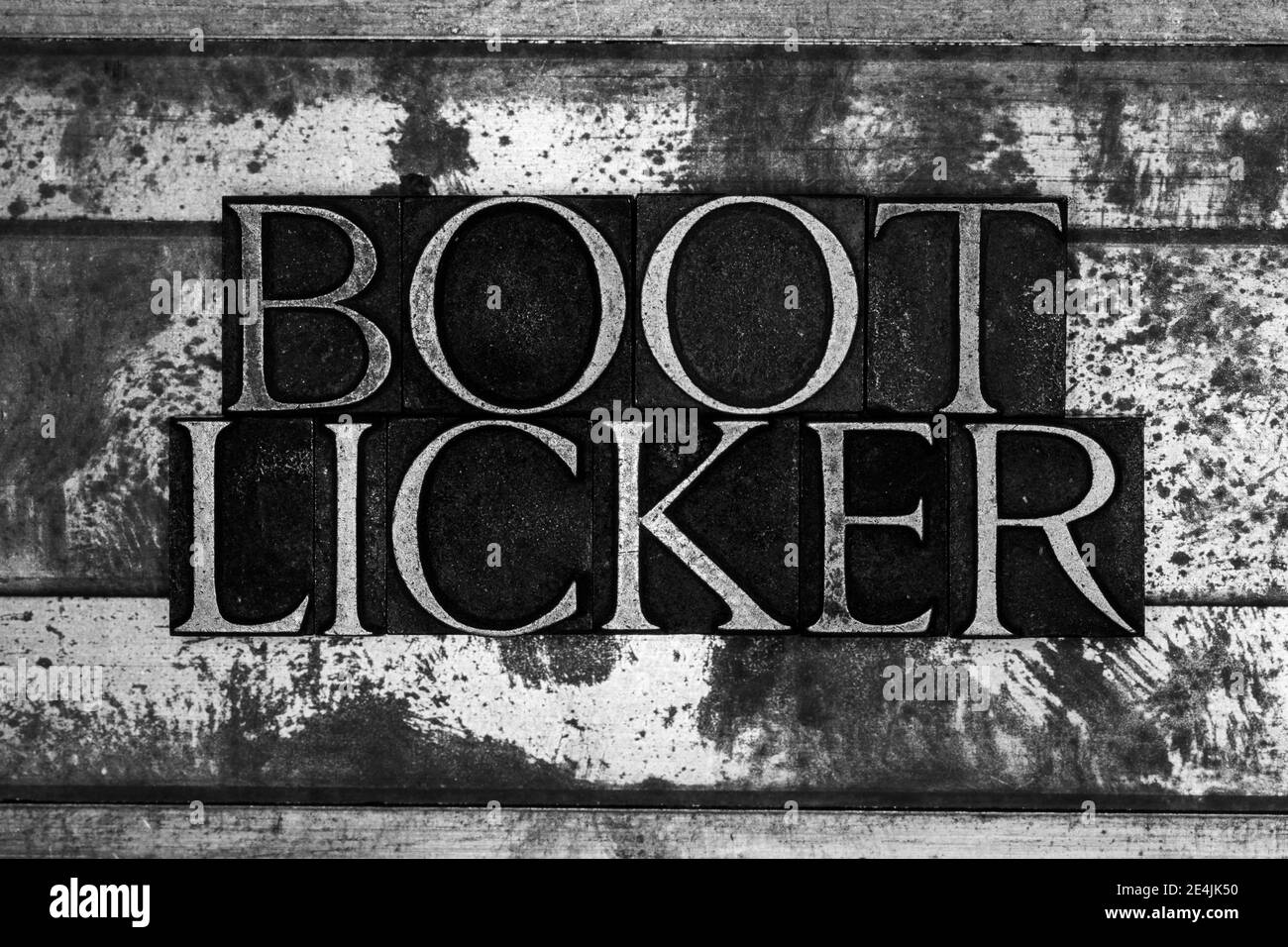 Boot Licker Text auf strukturiertem Grunge monochromen Metallhintergrund Stockfoto