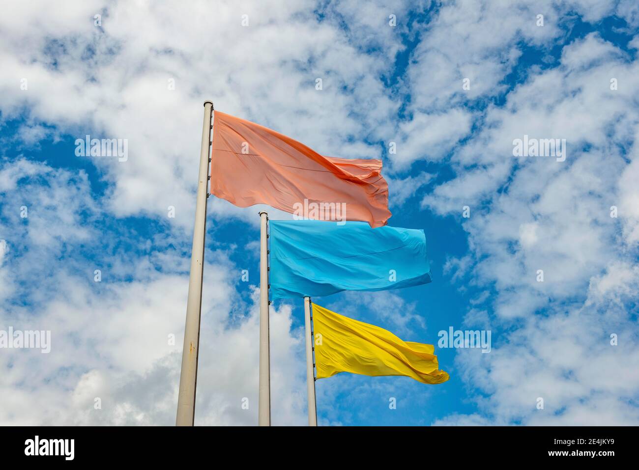 Rote, blaue und gelbe Flagge vor bewölktem Himmel, Berlin, Deutschland Stockfoto