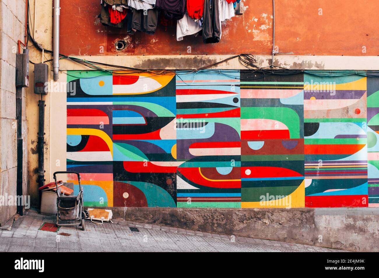 Bunte geometrische Wandkunst auf einer schäbigen Straße Stockfoto