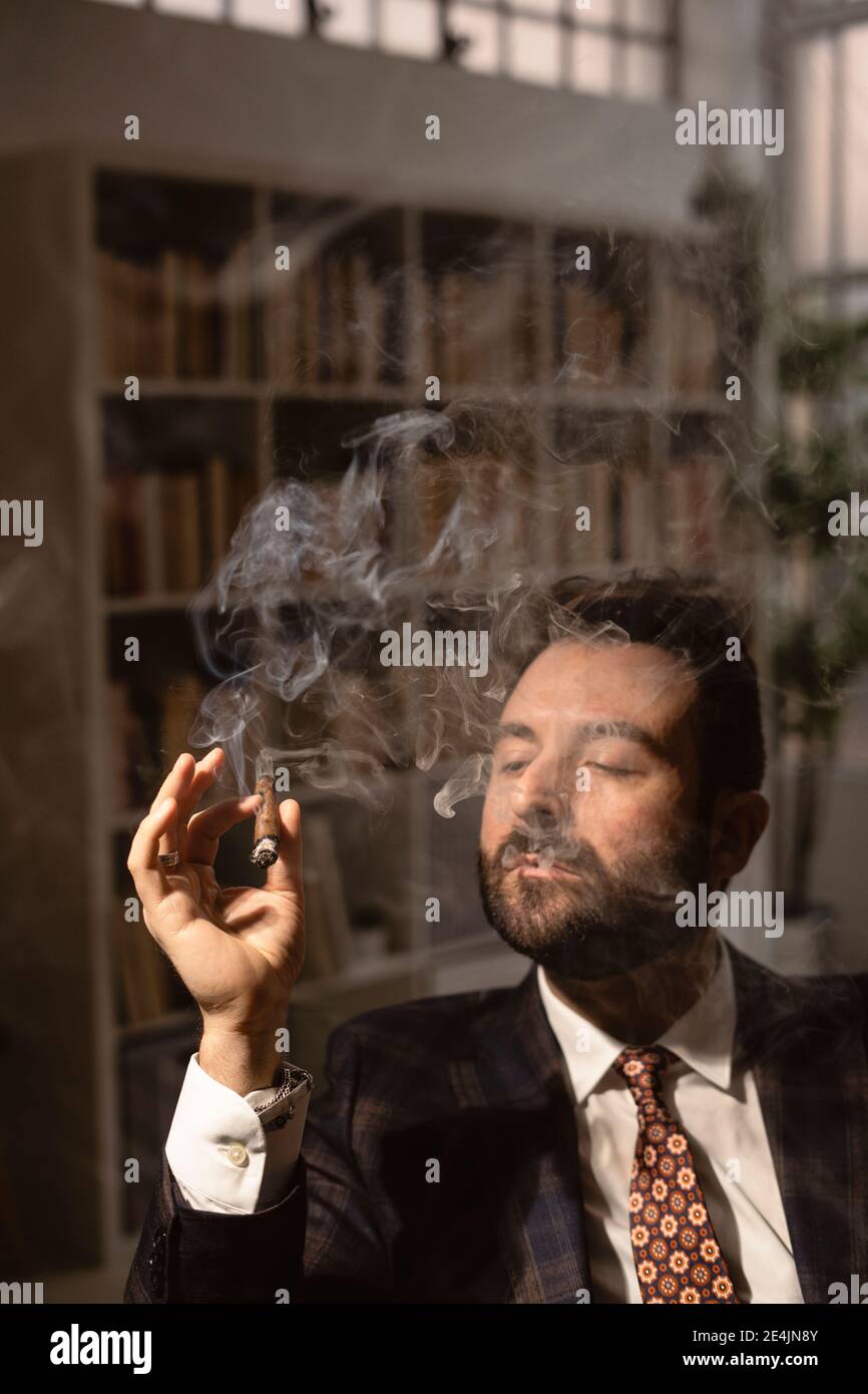 Porträt eines bärtigen Mannes, der Zigarre raucht Stockfoto