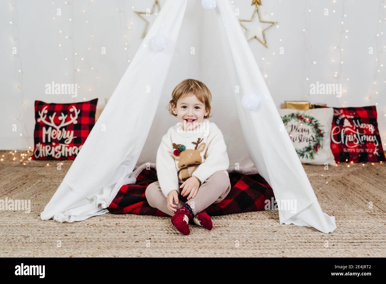 Nettes Baby Mädchen lächelnd, während im Zelt während Weihnachten sitzen Zu Hause Stockfoto