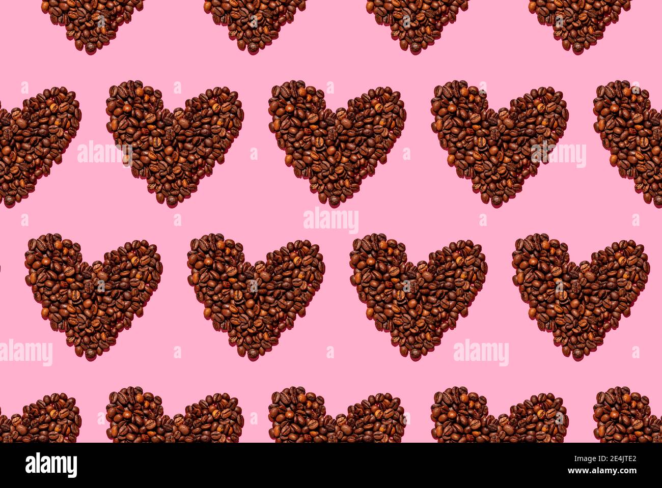 Muster von gerösteten Kaffeebohnen in Herzform angeordnet Stockfoto