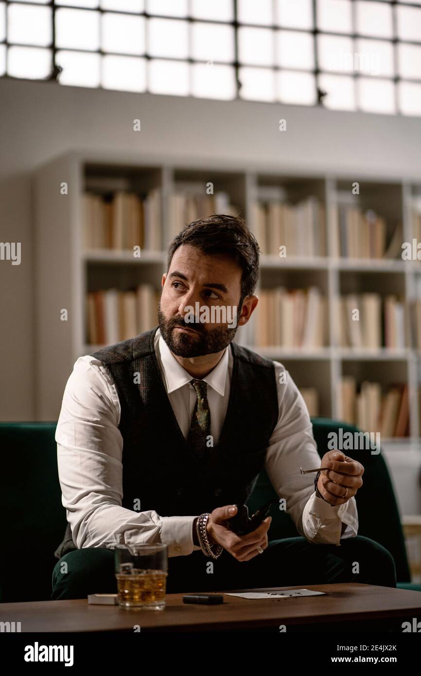 Porträt eines bärtigen Mannes, der Rauchpfeife vorbereitet Stockfoto