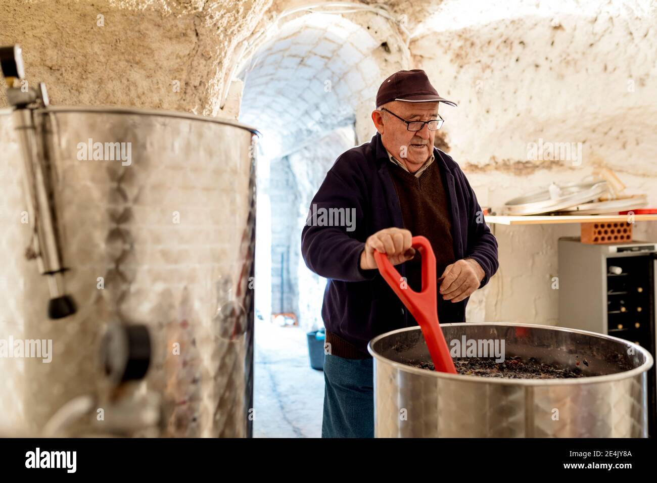 Älterer männlicher Winzer, der Wein in der Weinkellerei vorbereitet Stockfoto