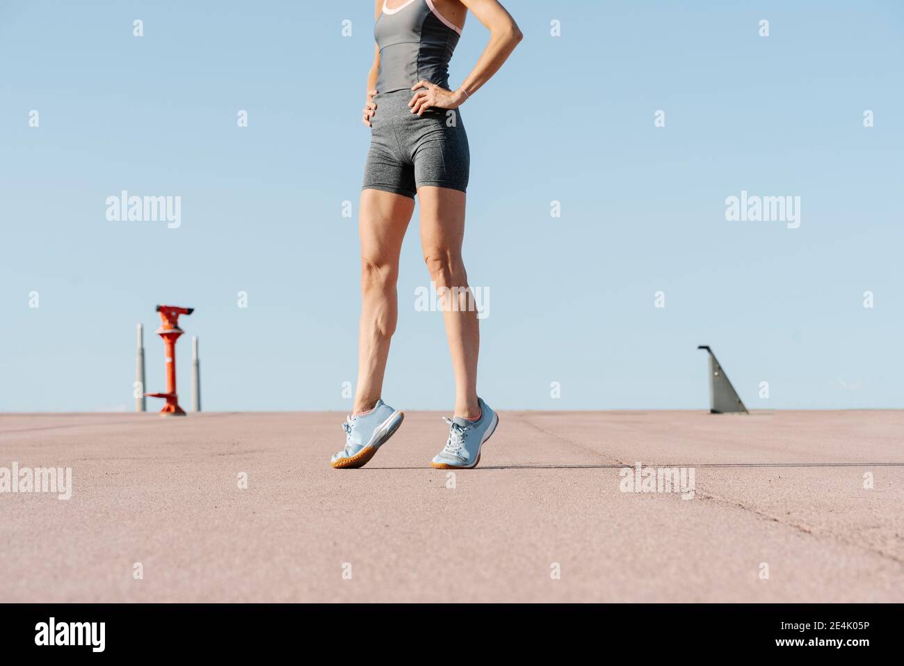 Weibliche Sportsperson mit der Hand auf der Hüfte auf der Zehenspitze Stockfoto