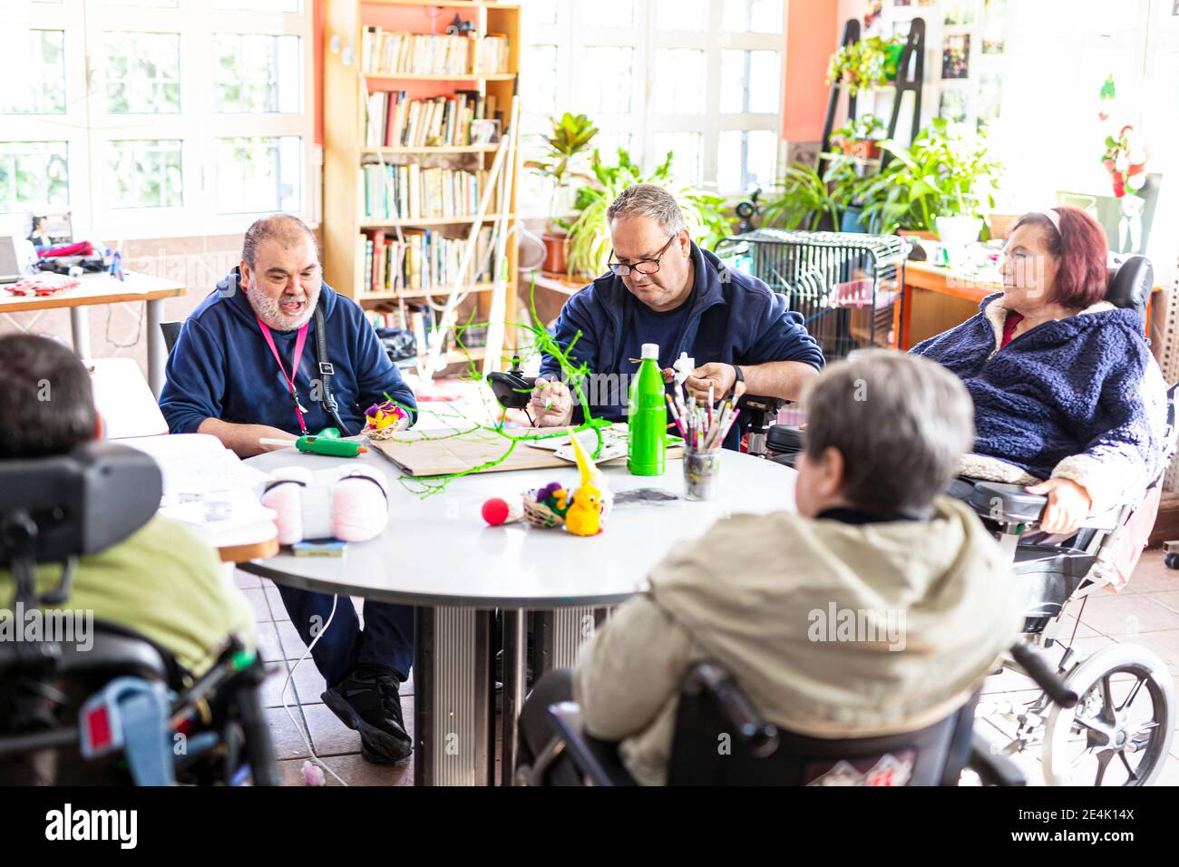 Behinderte Menschen tun Handwerk am Tisch im Pflegeheim Stockfoto
