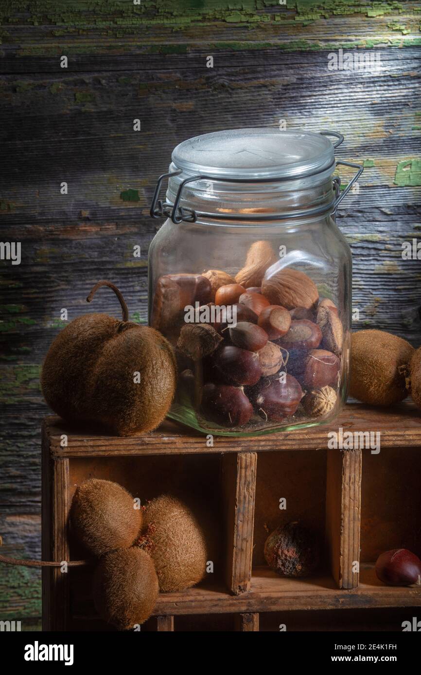 Foto von verschiedenen getrockneten und geformten Früchten Vertikal. Nahaufnahme. Sharp Light Studio. Kiwis und Muttern. Die meisten von ihnen in Glas Jar Stockfoto
