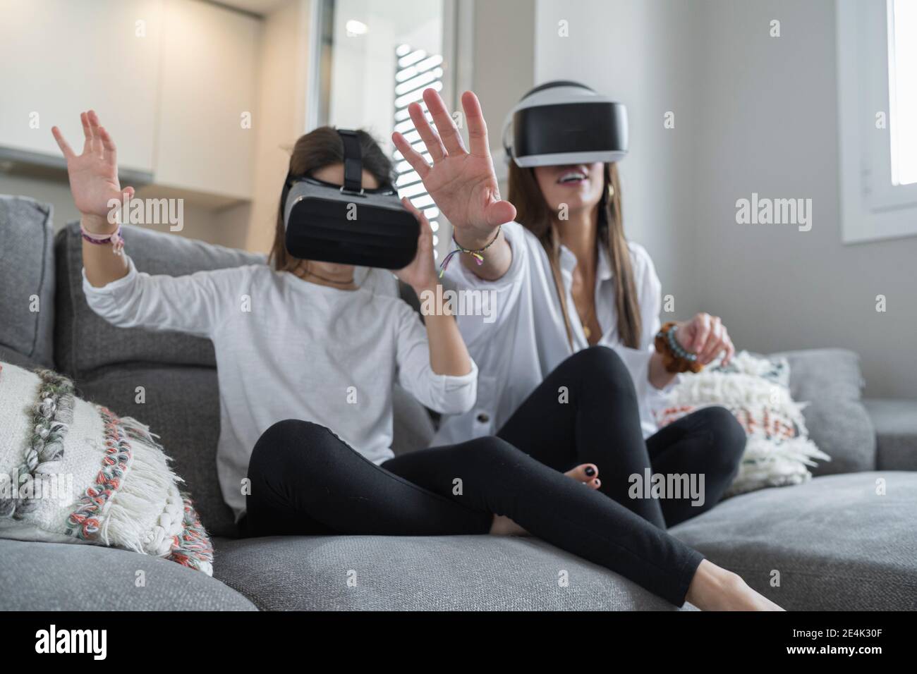 Tochter und Mutter tun Stop-Geste, während mit Virtual Reality Im Wohnzimmer Stockfoto