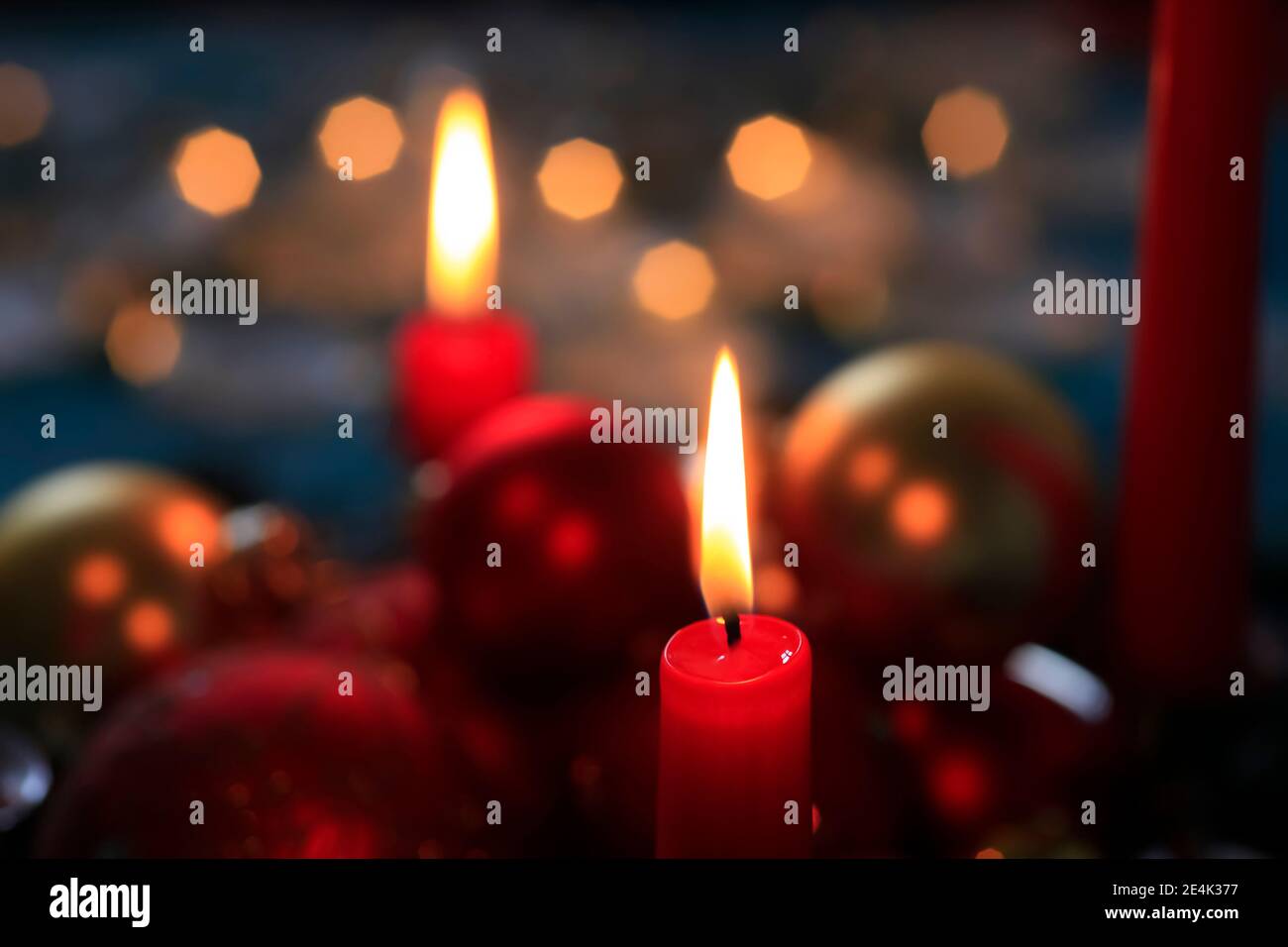 Rote brennende Adventskerzen und Weihnachtskugeln Stockfoto