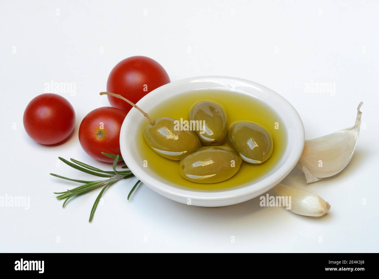 Grüne Oliven in Schale mit Olivenöl, olea spec., Chalkidiki Oliven, Tomaten, Rosmarin, Knoblauch, Mittelmeer, mediterrane Ernährung Stockfoto