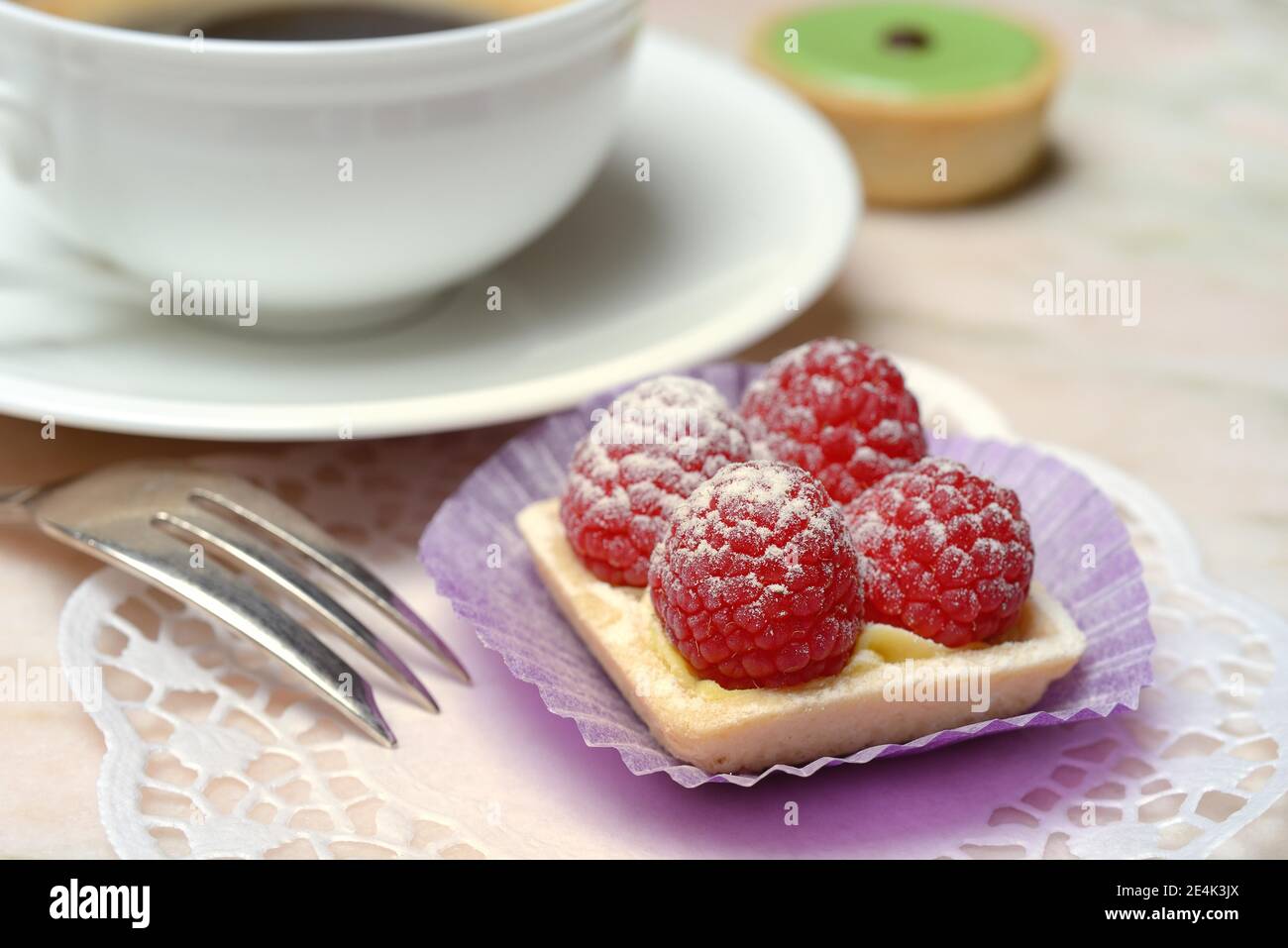 Patisserie mit Himbeeren und Kaffeetasse Stockfoto