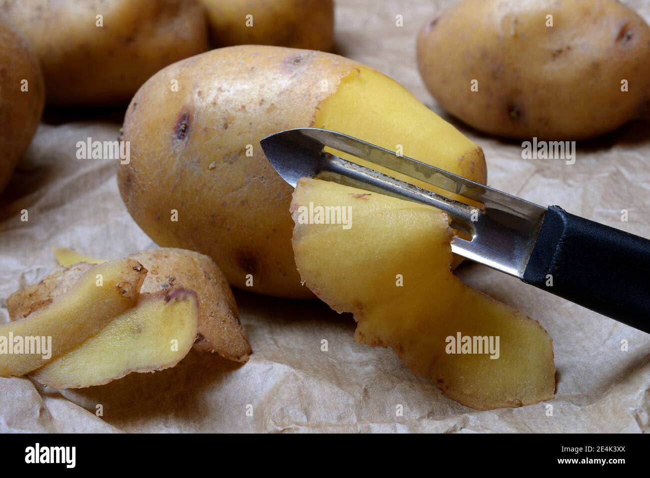 Kartoffelschälen mit Schäler, Solanum tuberosum, Kartoffelschalen, Kartoffelschalen Stockfoto