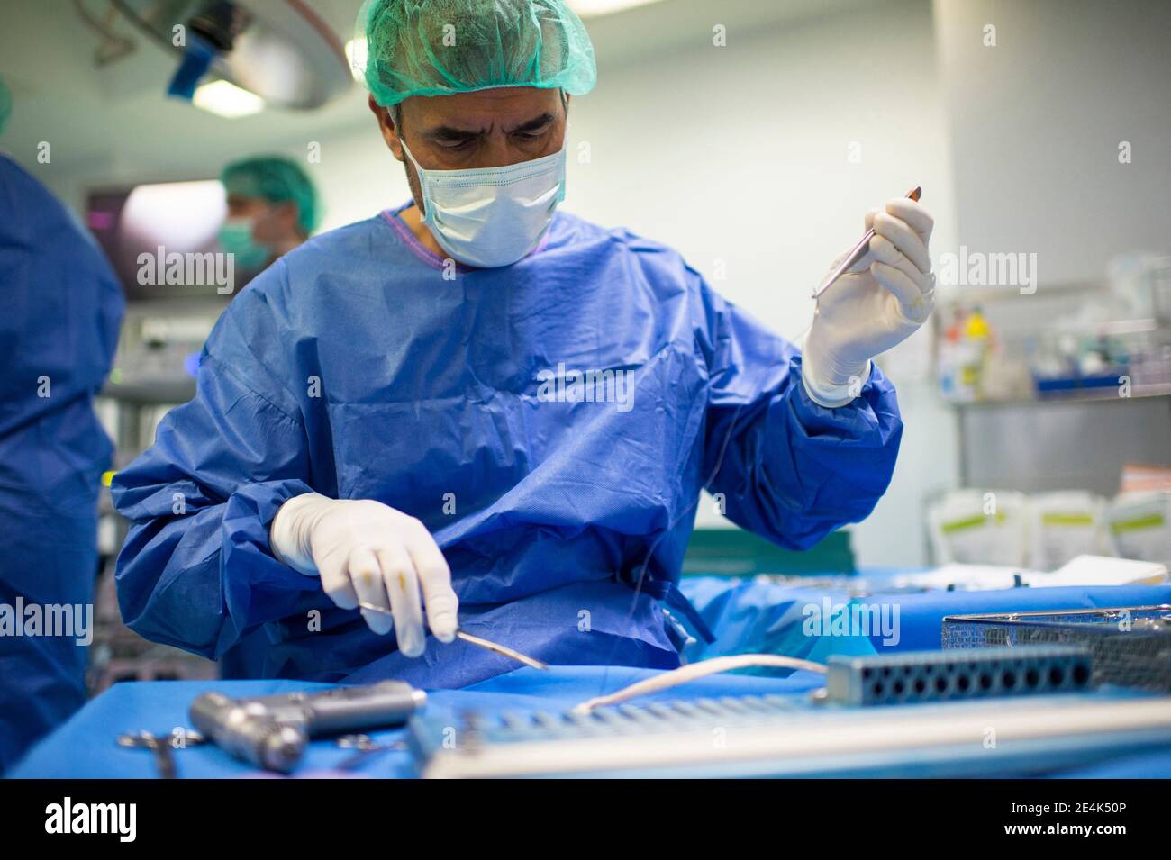 Orthopädischer Chirurg, der eine Pinzette für den Einsatz auf der Intensivstation vorbereitet Stockfoto