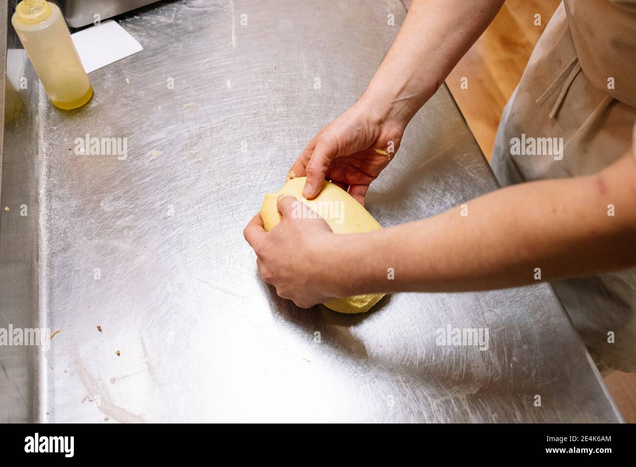 Männlicher Bäcker Kneten Brotteig in der Bäckerei Stockfoto